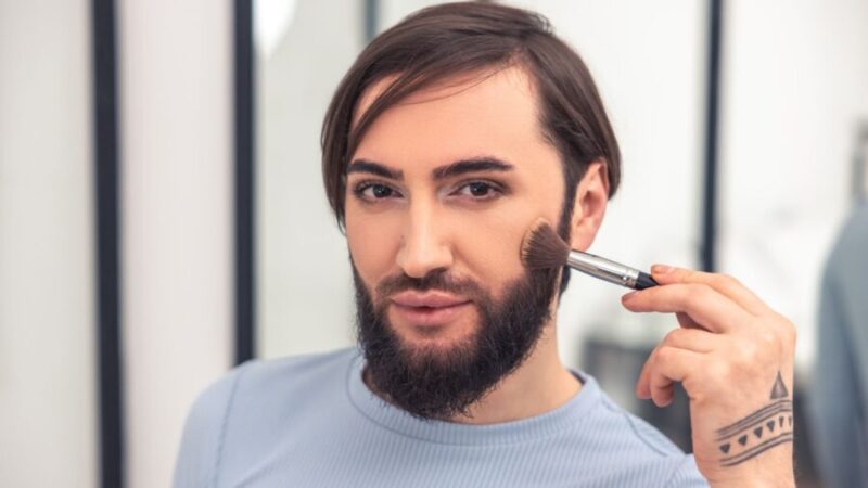 髭の上から化粧している男性